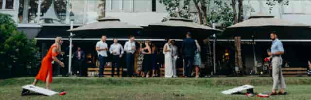 Stylish outdoor event at The Backyard, featuring guests mingling under umbrellas.