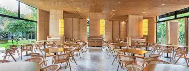 Modern dining hall in Min Jiang, featuring natural wood and flexible layouts for events.