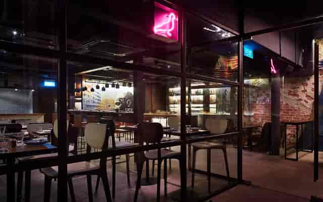 Modern cocktail bar with neon signage, perfect for events and gatherings.