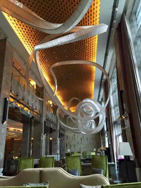 Bar at JW Marriott New Delhi with artistic ceiling, ideal for upscale events and networking.