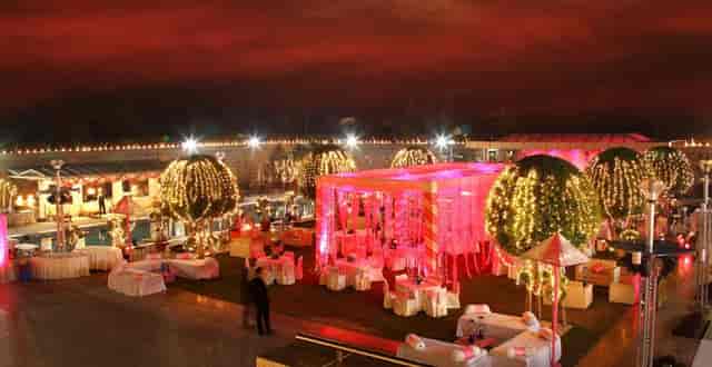 Elegant outdoor banquet hall with pink lighting, perfect for weddings and upscale events.