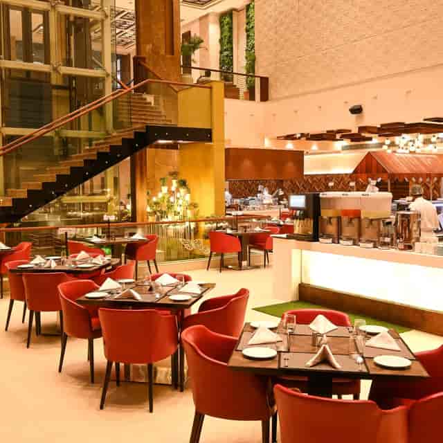 Modern restaurant with red chairs, perfect for networking events and gatherings.