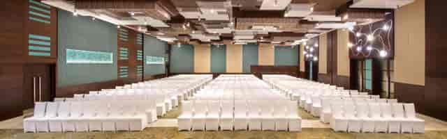 Banquet Hall at Crowne Plaza Greater Noida, modern conference space with white chairs.