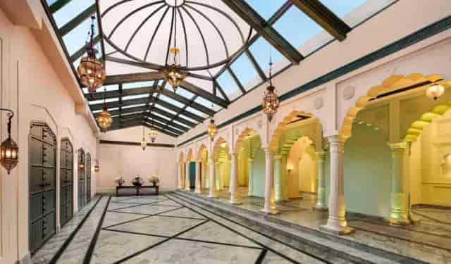 Elegant event space with arches and glass ceiling in Fairmont Jaipur for gatherings.