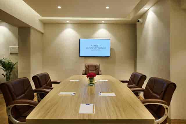 Banquet Hall at Sarovar Hotels, featuring a sleek wooden table for professional meetings.