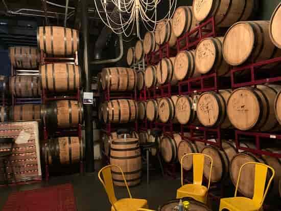 Bully Boy Distillers tasting room with wooden barrels, ideal for wine-tasting events.