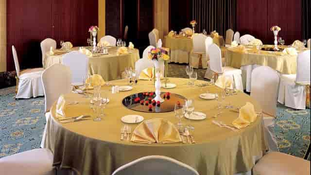 Elegant banquet room with gold tablecloths, perfect for weddings and corporate events.