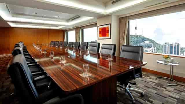 Modern conference room with wooden table, ideal for corporate meetings and events.