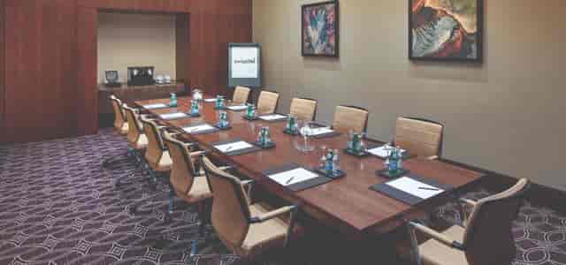 Conference Room at Swissôtel Al Ghurair, featuring a long wooden table for meetings.