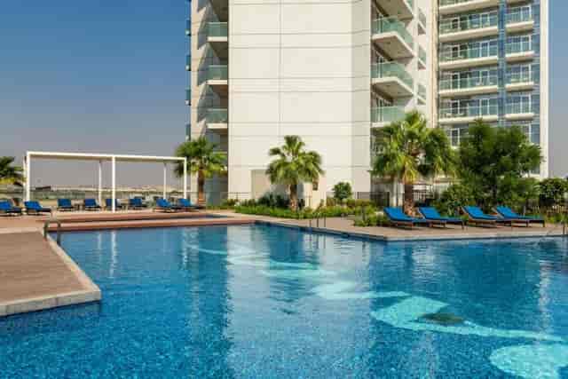 Birdie by a pristine pool at Radisson Hotel Dubai, perfect for corporate events and relaxation.