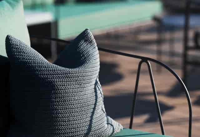 Stylish textured pillow on modern chair at The Rooftop, perfect for networking events.