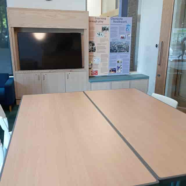 Modern meeting room with large wooden table at Southwark Heritage Centre for events.