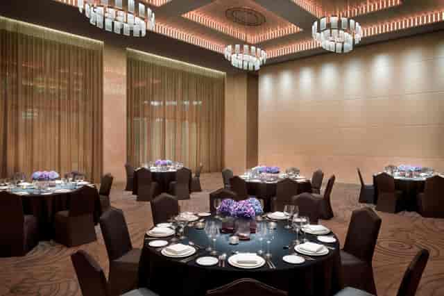 Elegant ballroom dinner setup with floral centerpieces for corporate events and weddings.
