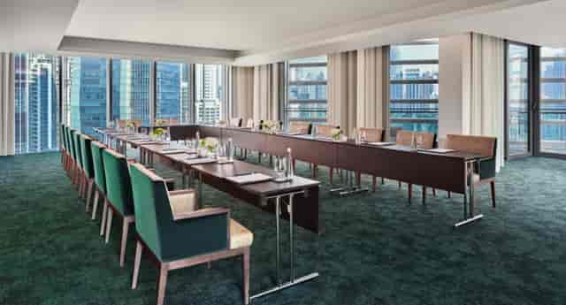 Modern meeting room with long table, ideal for corporate workshops and board meetings.