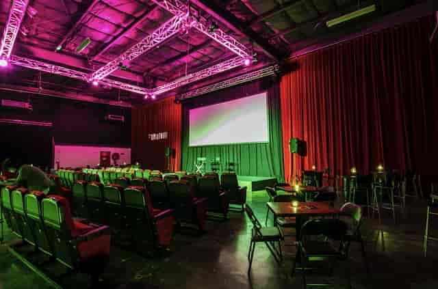 Versatile event space in Warehouse Four with tiered seating for presentations and screenings.
