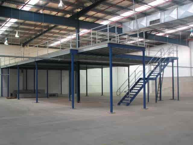 Spacious industrial venue with raised platform, ideal for corporate events and exhibitions.