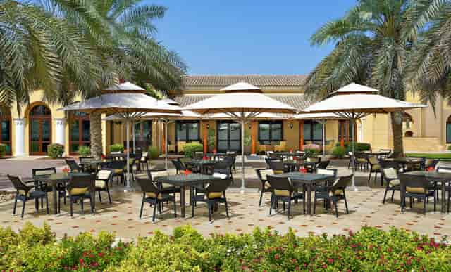 Equestrian club outdoor event space in Polo Club Dubai with shaded tables for networking.