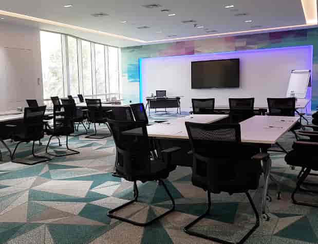 Modern training center meeting room with flexible seating for workshops and presentations.