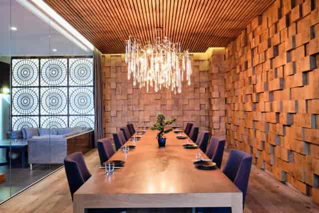 Sophisticated lounge with wooden table and plush purple chairs for executive meetings.