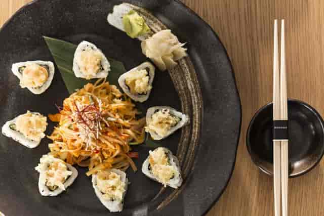 Elegant sushi platter with vibrant salad for upscale corporate events and celebrations.
