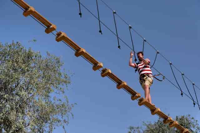 Participant navigating high ropes course at Aventura Parks for team-building event.
