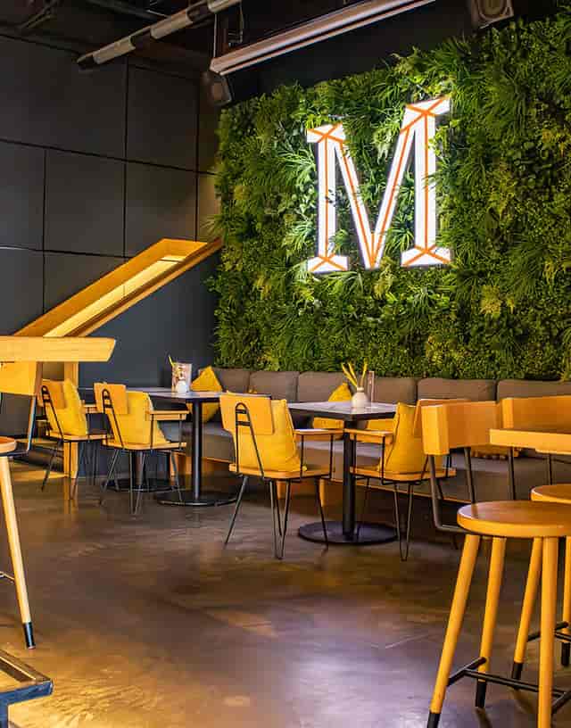 Modern event space with lush greenery, perfect for networking and gatherings.
