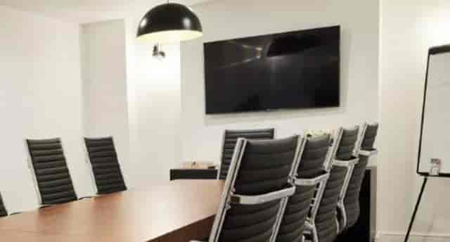 Modern conference room at Grosvenor House St Pauls with large wooden table for meetings.