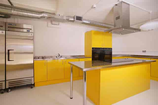 Modern kitchen with yellow cabinetry for culinary events and cooking classes in Tooting.