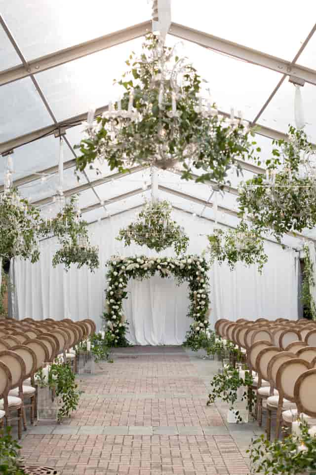 Elegant tented wedding venue with floral arch and chandeliers in Chicago.