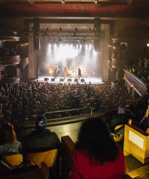 Vibrant live performance in Park West theater with tiered seating and great acoustics.