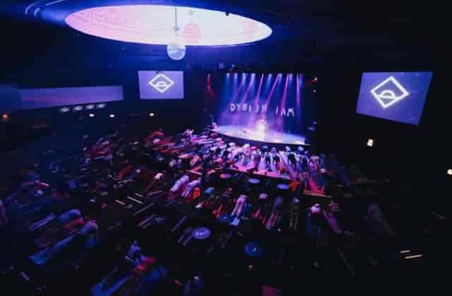 Yoga session in Park West theater with illuminated stage and immersive ambiance.