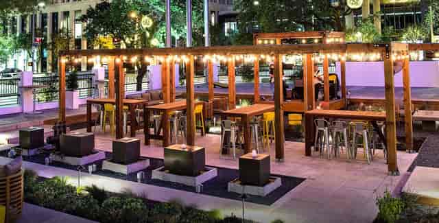 Stylish outdoor event space at The Whitehall Houston with string lights and fire pits.