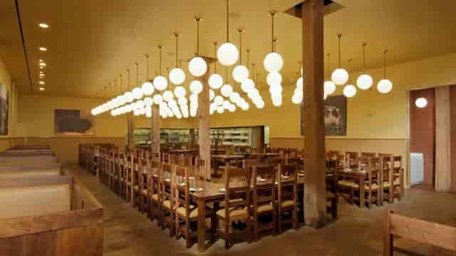 Spacious restaurant dining area with rustic tables, ideal for events and receptions.