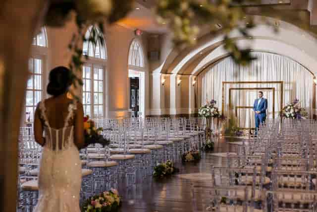 Elegant wedding ceremony setup in The Bougainvilleas with chiavari chairs and floral backdrop.