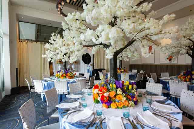 Elegant event space at Gusano Lounge with floral centerpieces and cherry blossoms.