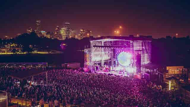Outdoor concert at White Oak Music Hall with vibrant crowd and city skyline backdrop.