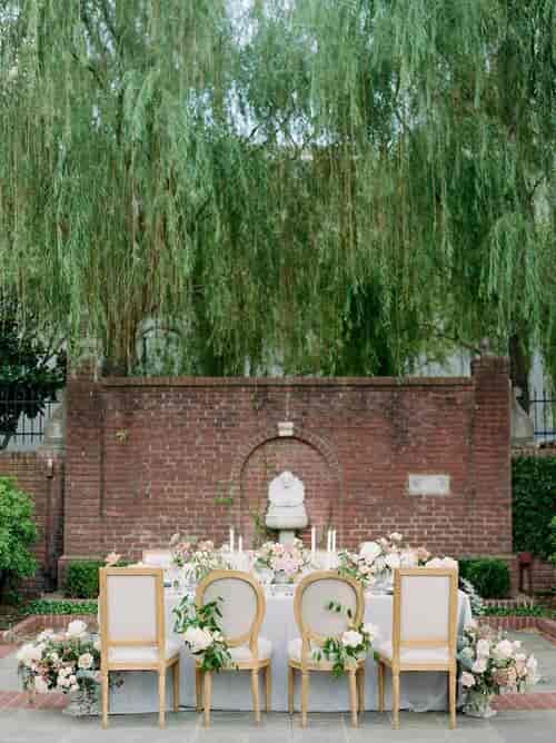 Outdoor wedding venue with brick backdrop and lush greenery at The Forum of Civics.