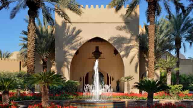 Arabian Court entrance at One&Only Royal Mirage, featuring elegant architecture and lush landscaping.