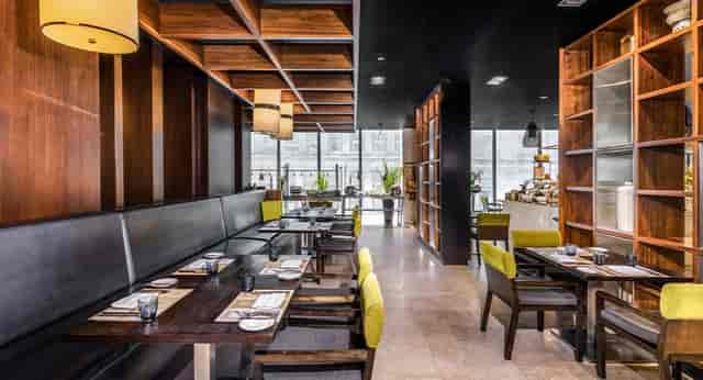 Modern Mövenpick restaurant interior with wooden accents, ideal for events and gatherings.