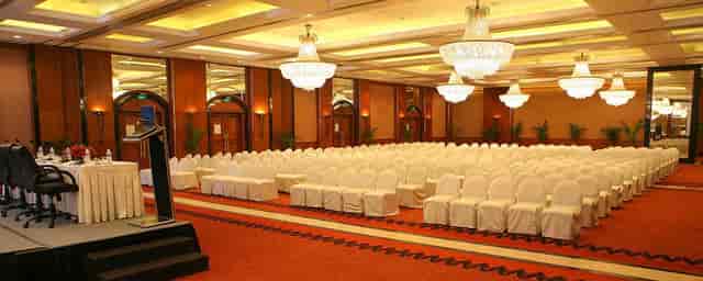 Elegant banquet hall with white-covered chairs, perfect for conferences and formal events.