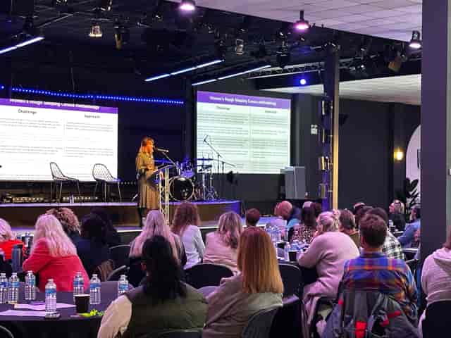 Auditorium event space with speaker engaging audience, ideal for conferences and meetings.
