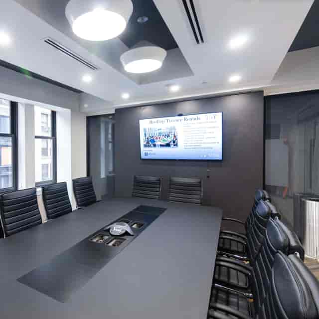 Modern conference room with sleek black table, ideal for professional meetings and presentations.