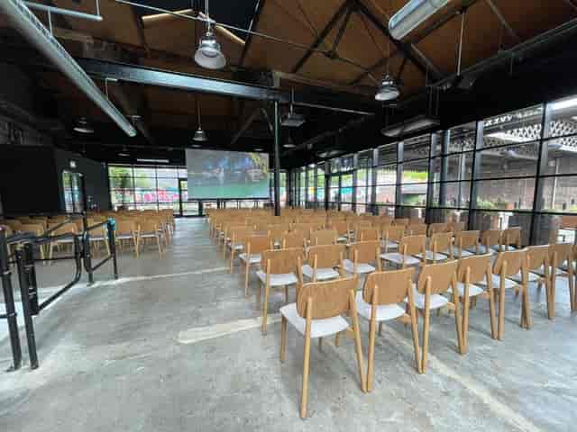 Spacious event venue at The Bond, featuring wooden chairs for presentations and natural light.