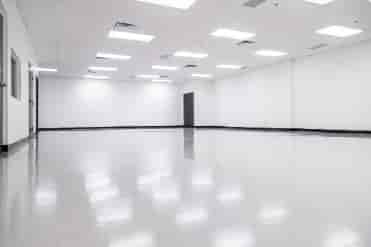 Spacious empty meeting room with polished floors for corporate events and workshops.