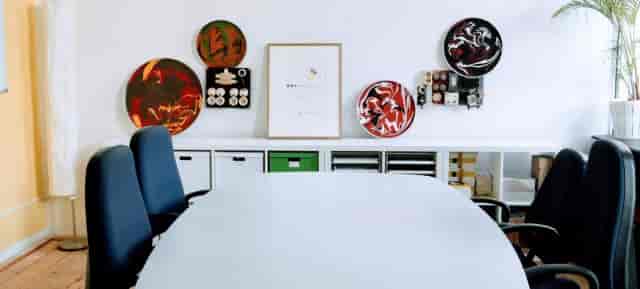 Modern meeting space in MACHWERK with round table, colorful art for collaboration.