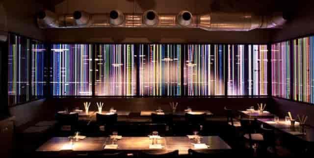 Modern Bar Tausend restaurant with vibrant wall art, ideal for private events or gatherings.