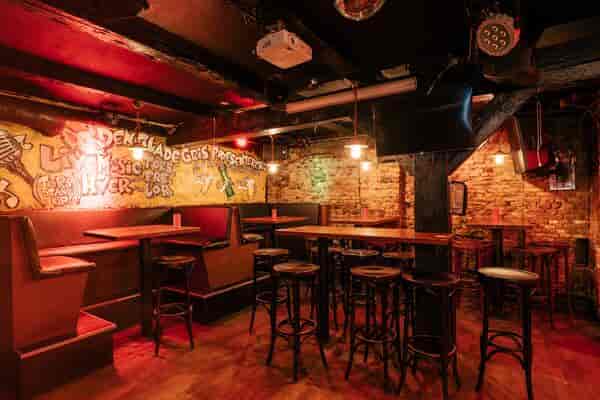 Intimate event space with exposed brick and cozy seating for workshops or live music.