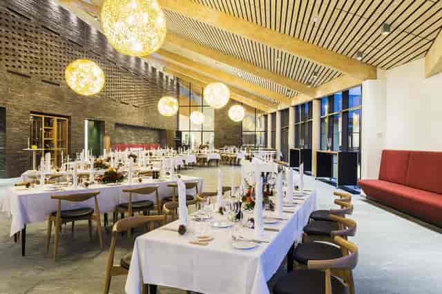 Elegant event space at Orangeriet, featuring long tables for meetings and dinners.
