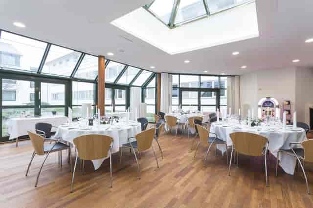 Elegant event space with round tables, ideal for meetings and formal events at Glostrup Hotel.