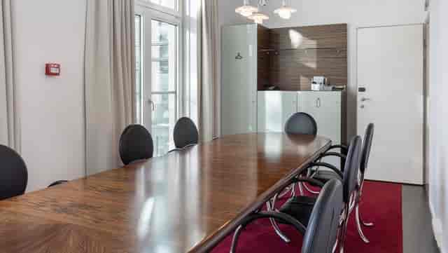 Modern meeting room in Copenhagen with wooden table, ideal for corporate events.